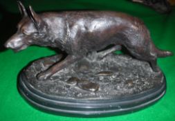 AFTER E. DROUOT "Prowling Wolf" a patinated bronze figure on an oval marble plinth base 25.