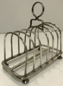 A late Victorian silver four section toast rack of plain form on turned feet (by Richard Martin &