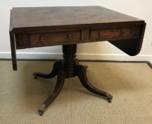 A late Regency mahogany drop-leaf sofa table with two frieze drawers opposite two dummy drawers,