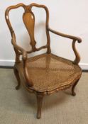 An early 20th Century elbow chair with bergère seat and vase shaped back splat,