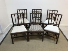 A set of six 19th Century mahogany dining chairs with carved back rails over a drop-in seat,