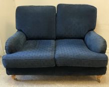 A pair of modern blue upholstered two seat sofas in the Howard style with curved side rails raised