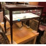 A 20th Century mahogany framed bijouterie table with rising top over the glazed sides,