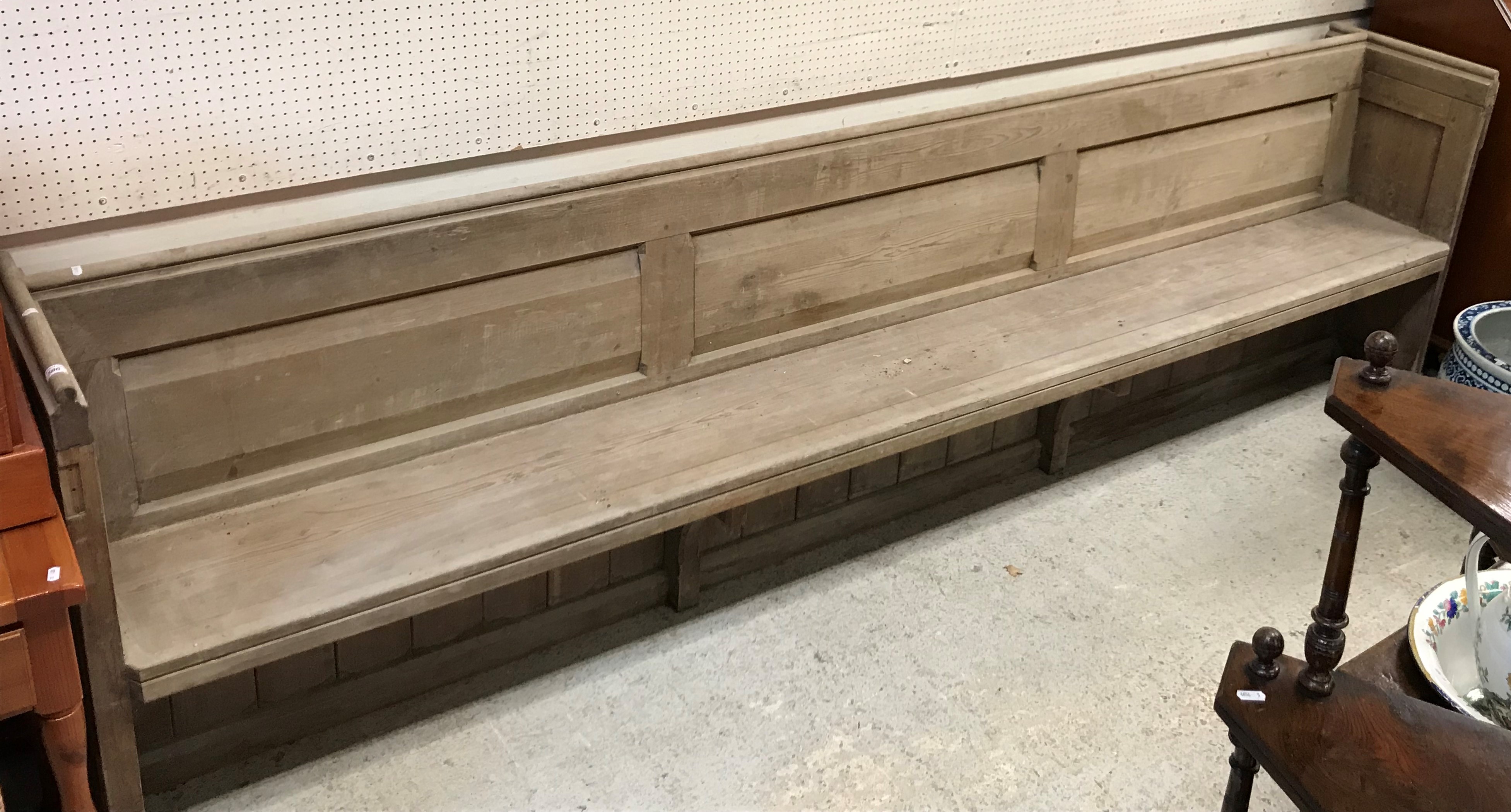 A circa 1900 stained pine pew of plain form on plank end supports, - Image 2 of 2