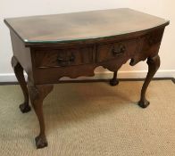 An early 20th Century walnut bow fronted three drawer side table in the Georgian taste,