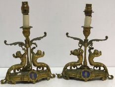 A pair of 19th Century gilt brass table candlesticks as putti with scrolling acanthus bases,