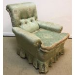 A late Victorian buttoned upholstered scroll armchair on turned and ringed front legs to later