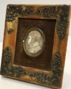 A 19th Century carved ivory portrait medallion on a gentleman in a high collared coat,