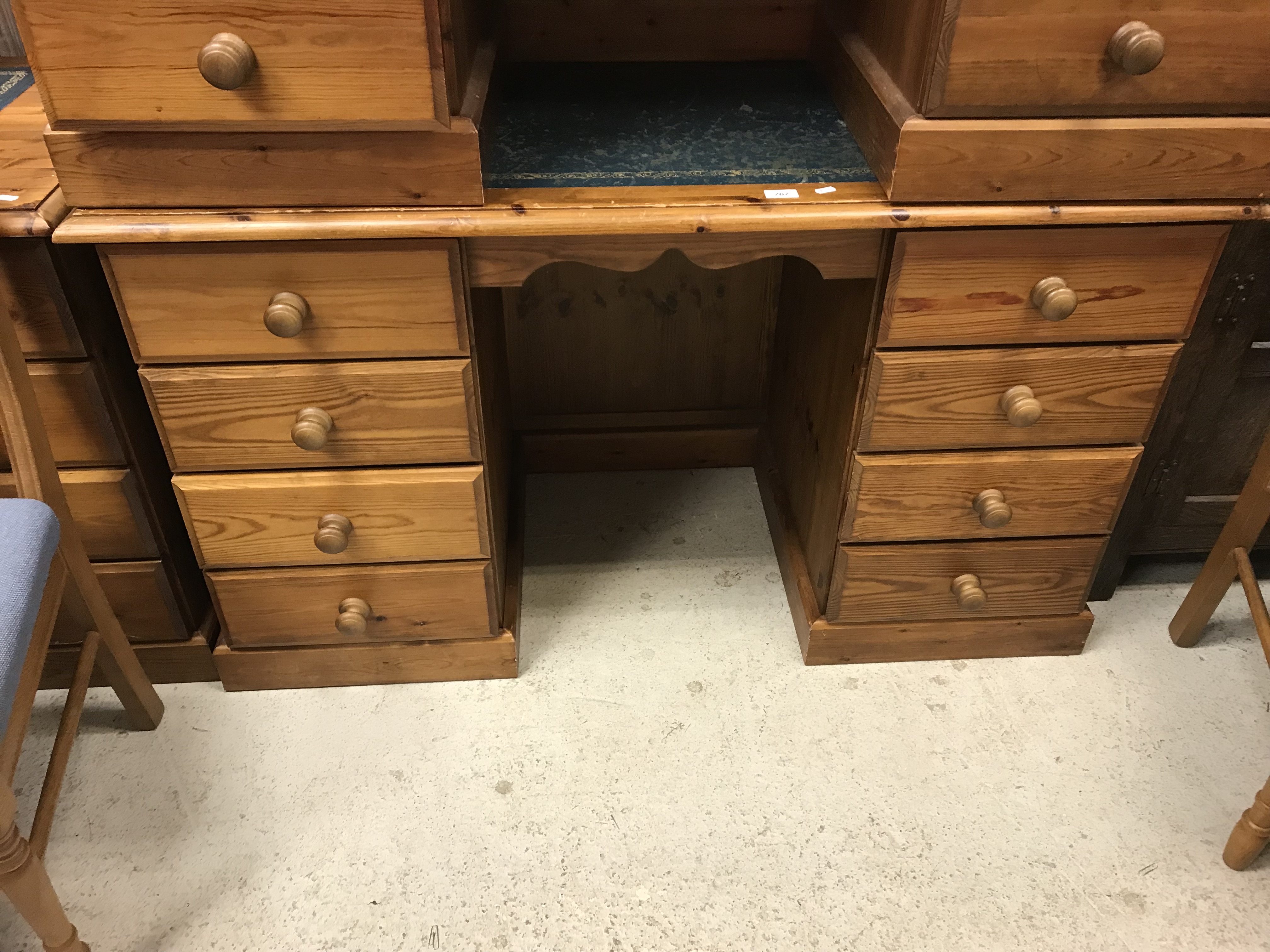 A modern pine writing desk, the plain top with leather insert above two banks of four drawers,