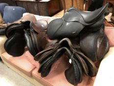A collection of eight various general purpose saddles,