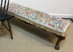 An early 20th Century walnut framed long stool with tapestry seat on acanthus carved cabriole legs