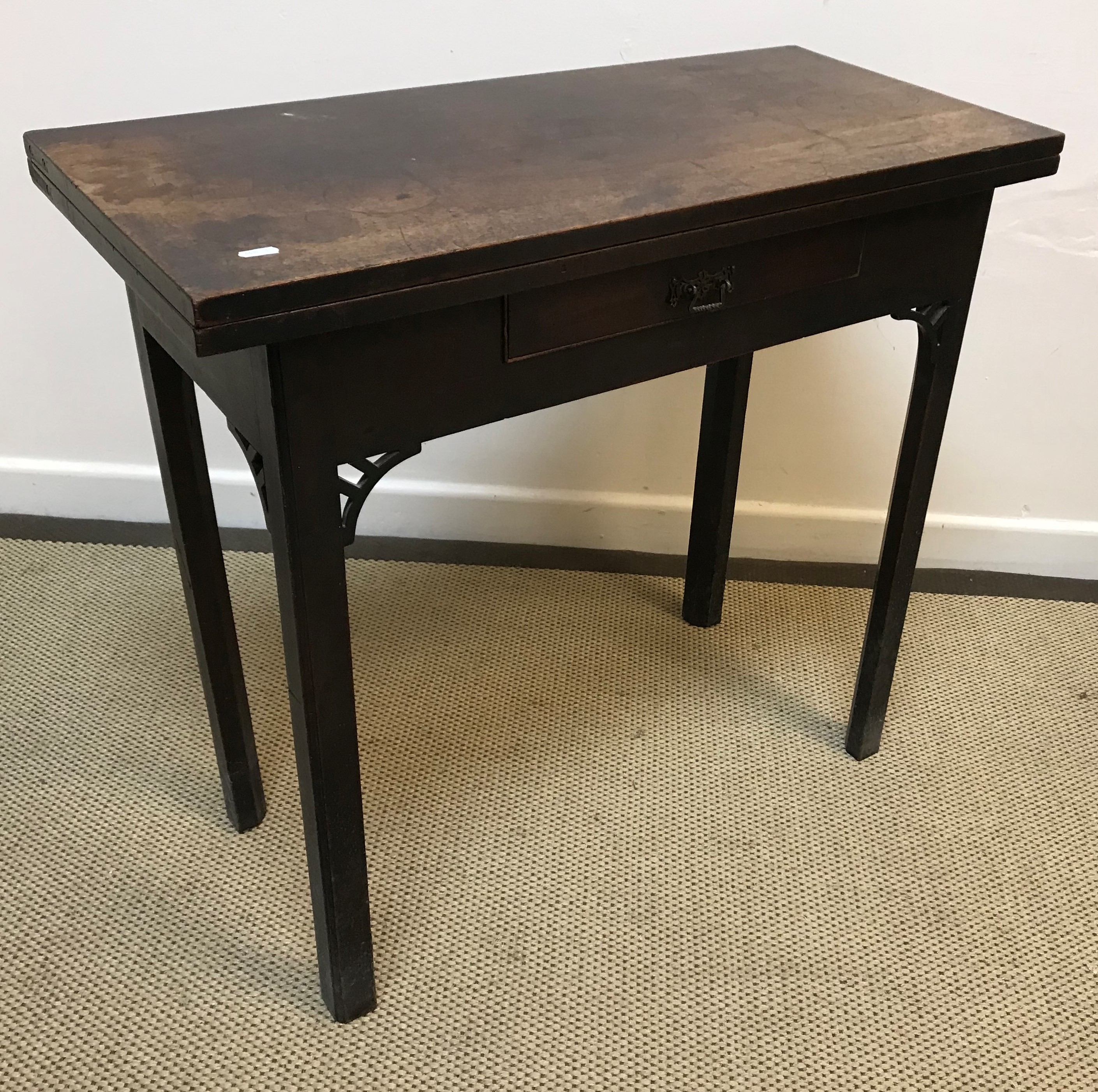 A George III mahogany fold-over tea table, the plain top above a single frieze drawer,