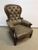 A Victorian mahogany framed button back leather upholstered salon armchair on turned front legs,