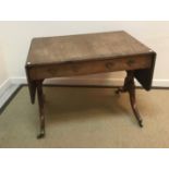 An early 19th Century mahogany and inlaid sofa table with rounded rectangular drop leaves over two