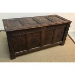 A circa 1700 oak coffer, the four panel top opening to reveal a candle box over a guilloche,