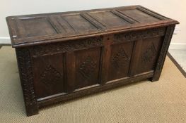 A circa 1700 oak coffer, the four panel top opening to reveal a candle box over a guilloche,