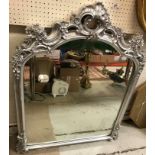 A modern silvered framed mantel mirror in the Rococo taste with scrolling foliate and floral