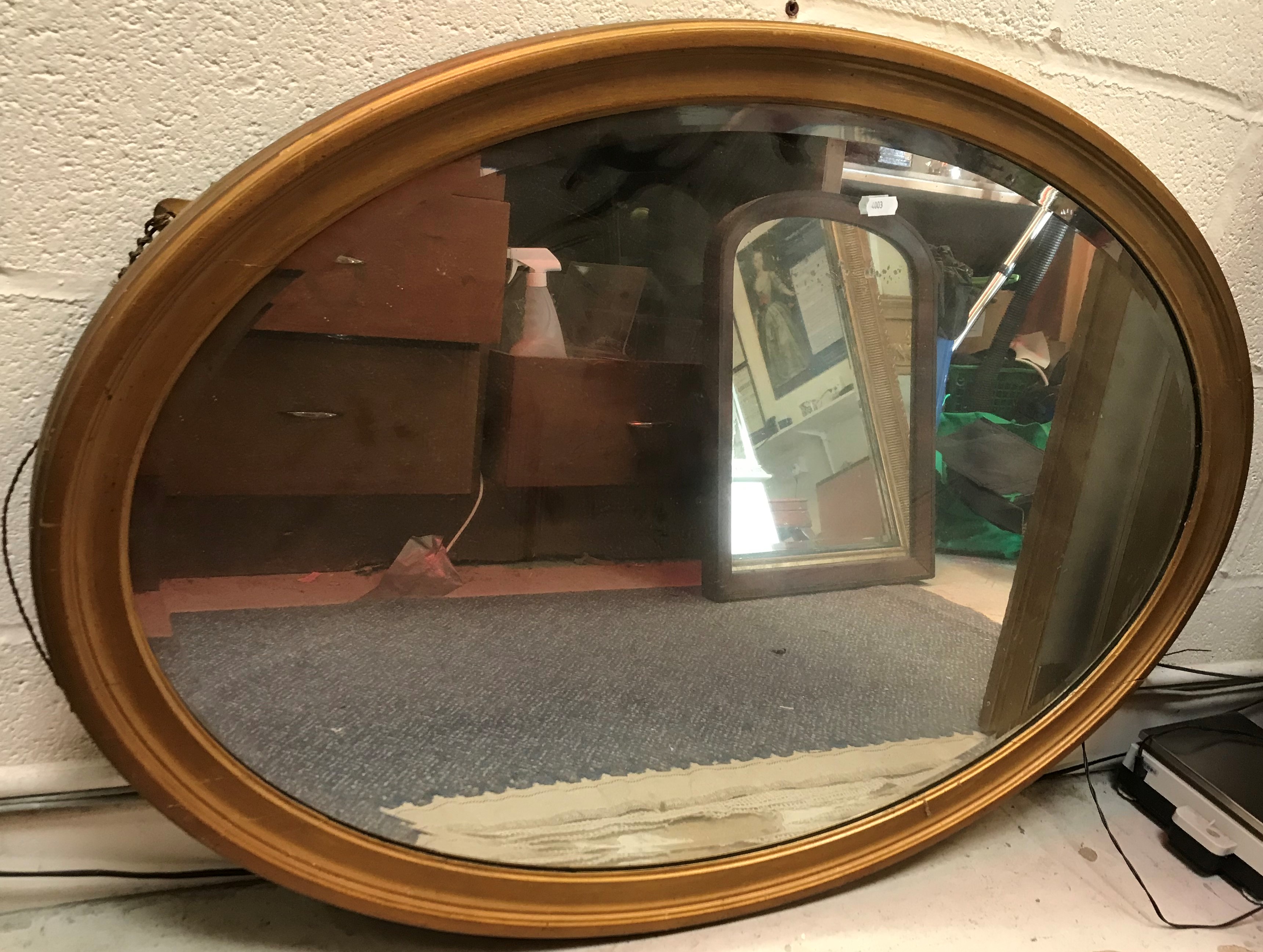 A gilt framed oval wall mirror with bevel edged plate, 97 cm wide x 67 cm high,