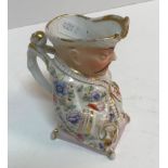 A late 19th Century Continental polychrome decorated porcelain cream jug as a seated Mandarin,