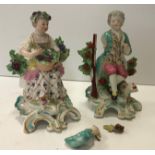 A pair of Chelsea figures of "Man seated with gun and bird in his hand",
