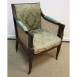A Regency mahogany framed bergère library armchair with caned back,