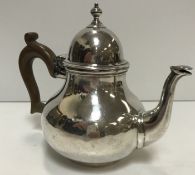 A Britannia Silver teapot of squat bellied form with domed lid and wooden handle (by Bert & Co.