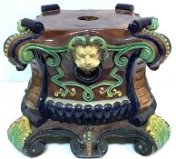 A Victorian majolica jardinier stand of shaped square form with lion mask ring scrollwork and