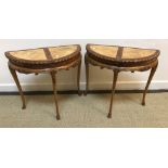 A pair of walnut and mahogany demi-lune side tables with moulded edge,