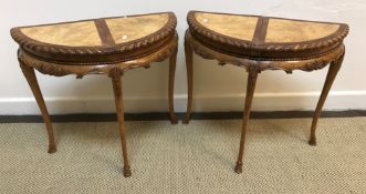 A pair of walnut and mahogany demi-lune side tables with moulded edge,