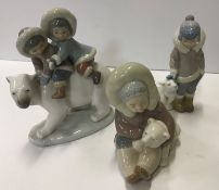 A collection of three Lladro Eskimo figure groups including "Two children upon the back of a Polar
