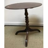A late George III oak tea table, the oval snap top on a turned and ringed pedestal to tripod base,