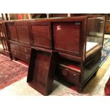 An early 20th Century brass framed and mahogany and glazed shop counter with four sliding doors