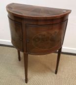 An Edwardian mahogany and inlaid cupboard of demi-lune form,