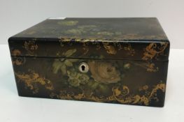 A Victorian black lacquered and gilt decorated and painted work box of rectangular form decorated