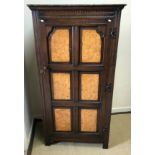 A mid 20th Century oak hall cupboard, the door with six burr walnut veneered fielded panels,