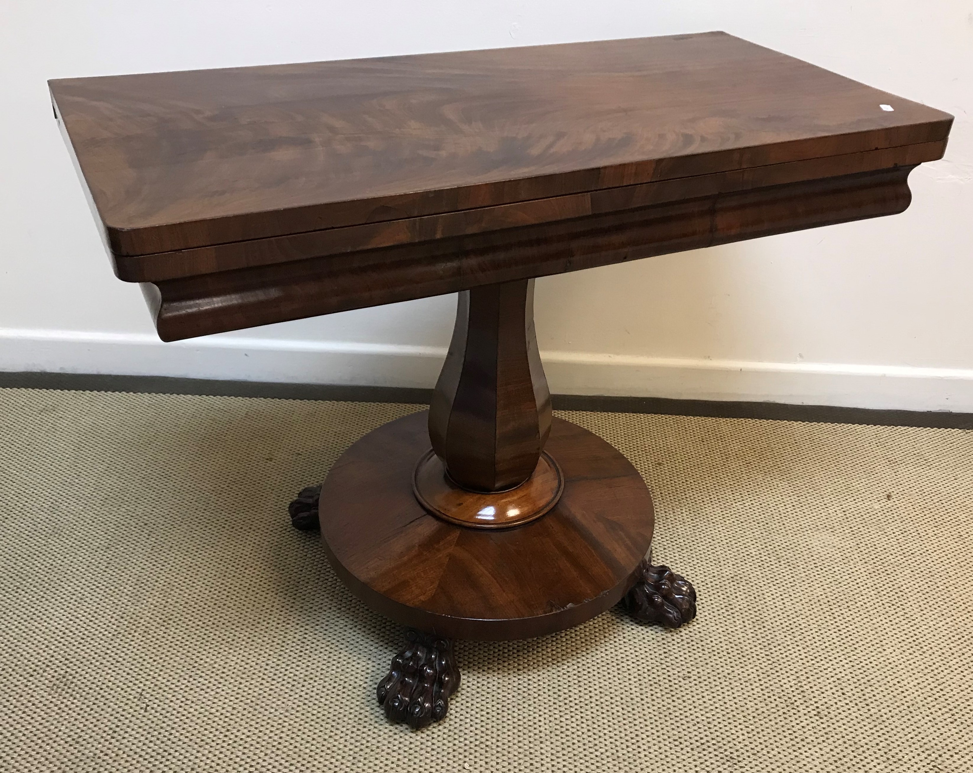 A Victorian mahogany tea table, the figured top opening to reveal a plain interior,