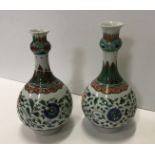 A matched pair of Chinese Kangxi famille verte onion-shaped vases with all-over scrolling floral