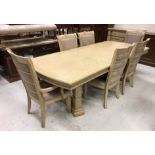 A modern stained oak and ash extending dining table on square ringed supports united by a centre