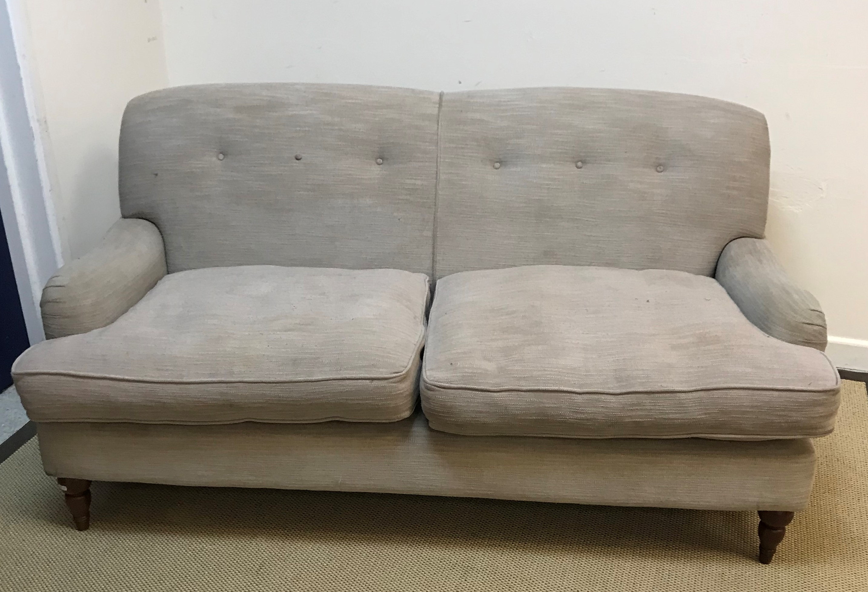 A modern mushroom or taupe upholstered two seat sofa in the Howard manner,