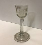 An 18th Century cut glass wine with rose engraved decoration, raised on a circular folded foot, 14.