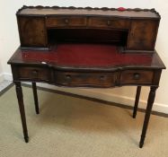 A reproduction mahogany lady's writing table with raised superstructure of drawers and cupboard