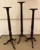 Three mahogany torchere stands on tripod bases,