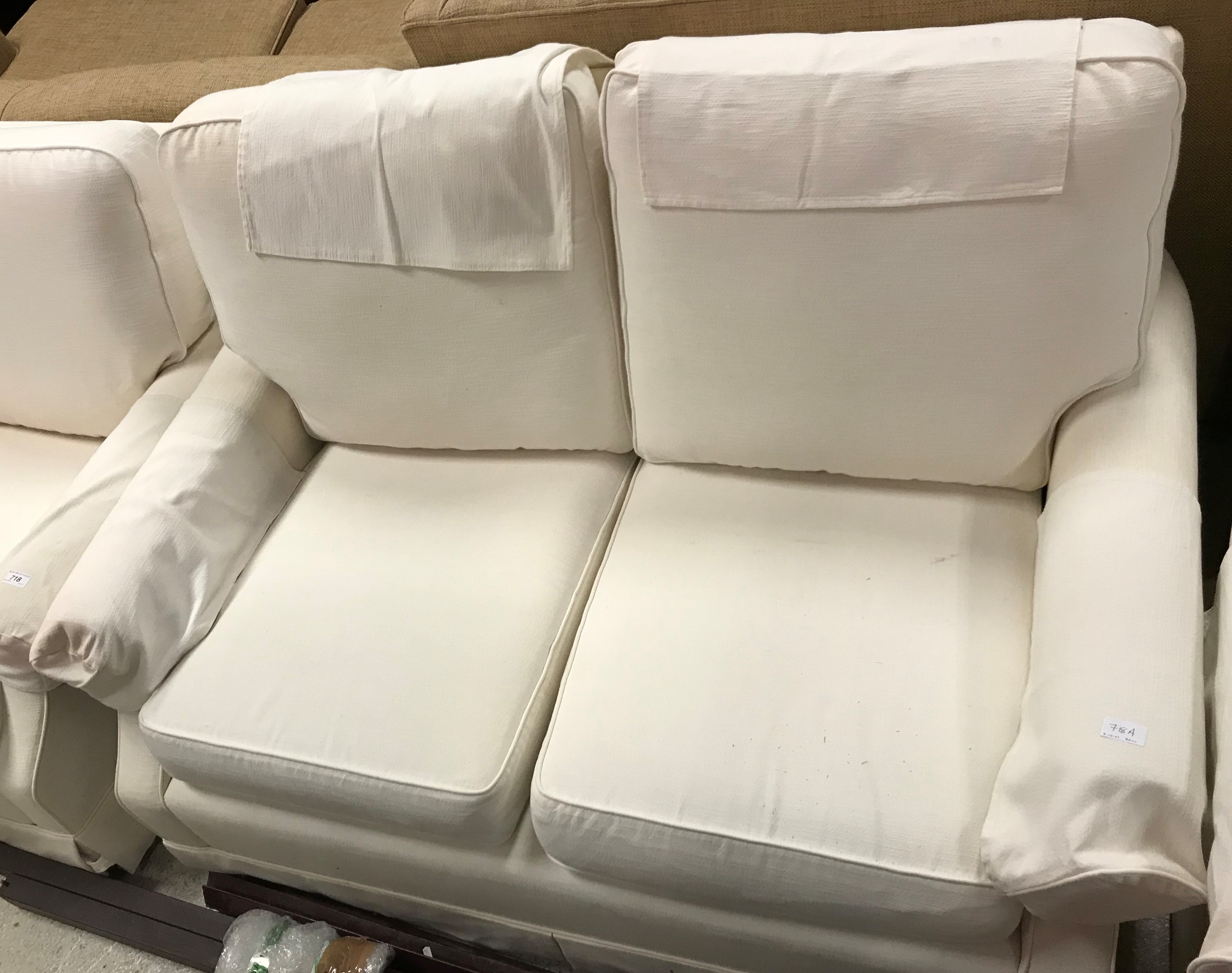 A Wesley Barrell cream ground two seat scroll arm sofa,