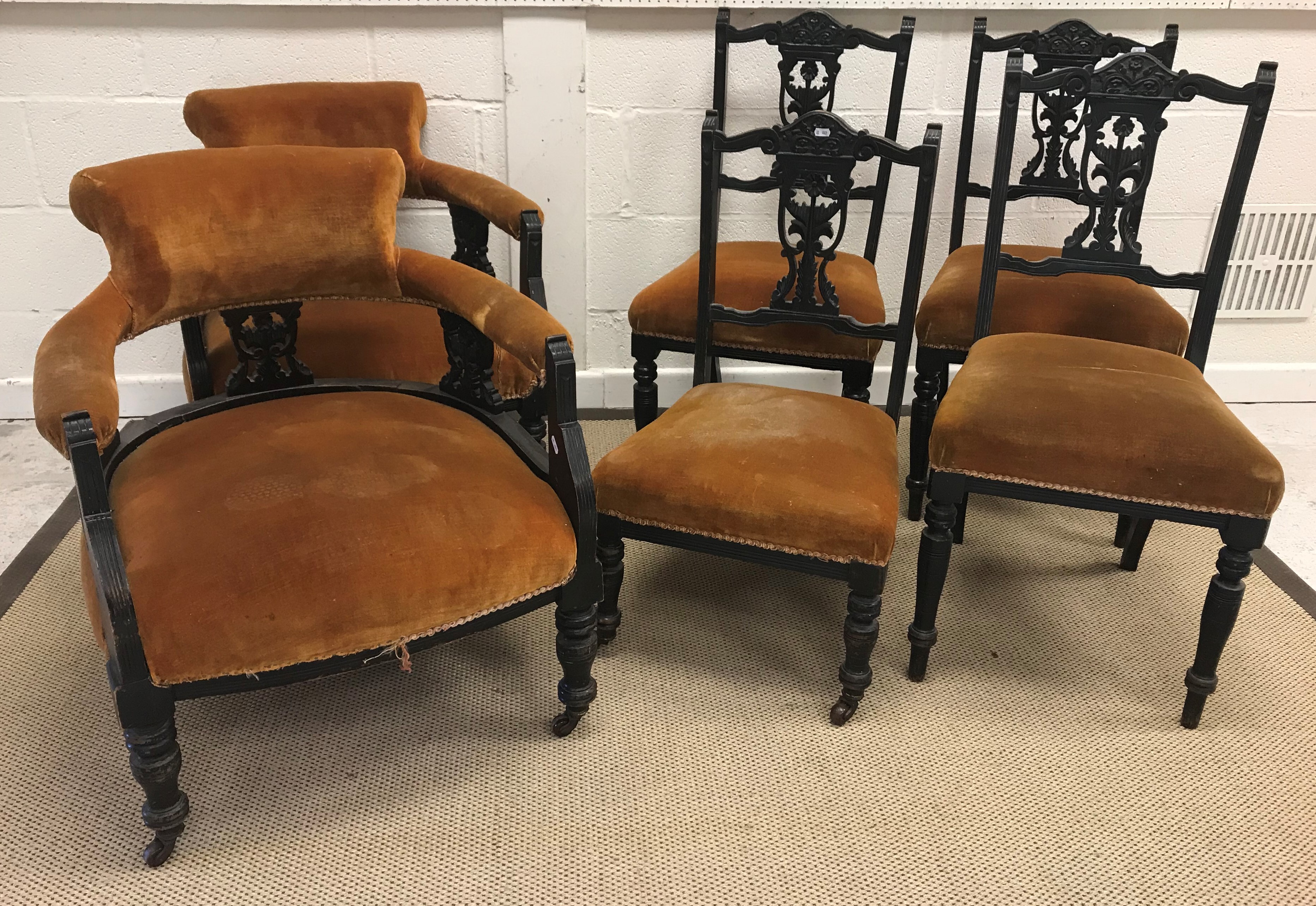 A Victorian ebonised salon suite of two tub chairs and four standard chairs CONDITION