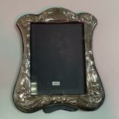 A modern silver photo frame in the Art Nouveau taste with embossed daffodil decoration (London 1986