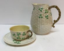A collection of Belleek "Shamrock and basket" decorated tea wares including two teapots,