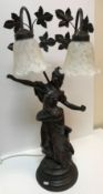 A bronzed table lamp in the Art Nouveau style with figural decoration and two frosted glass lamps