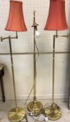 A pair of modern satin brass adjustable standard lamps and another standard lamp