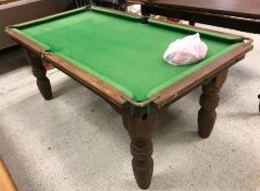 An EJ Riley quarter size snooker table of child's proportions, raised on turned legs,