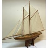 An early 20th Century clinker built pond yacht, twin masted with spinaker on bespoke stand,